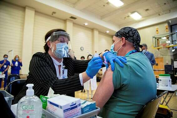 עובד בריאות מקבל את החיסון לקורונה בטורונטו שבקנדה, בשני // צילום: רויטרס