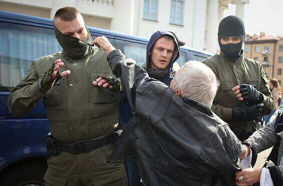 קשישה מתעמתת עם שוטרים רעולי פנים במינסק // צילום: איי.פי