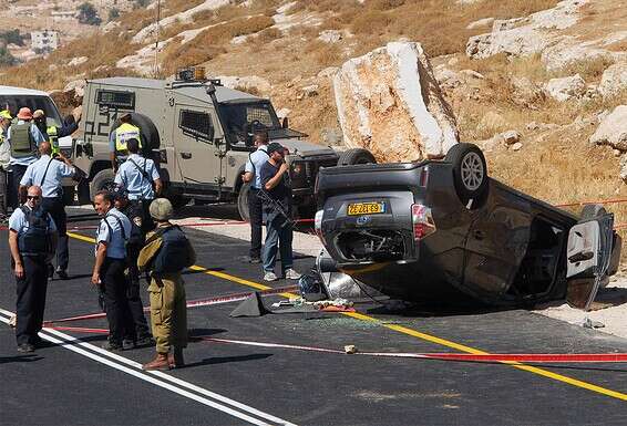 מכוניתה ההפוכה של משפחת מרק בזירת הפיגוע, יולי 2016. "המראות היו קשים, דם על הכביש, קליעים. אני גם בן אדם, וגם אני פחדתי" // צילום: אי.אף.פי