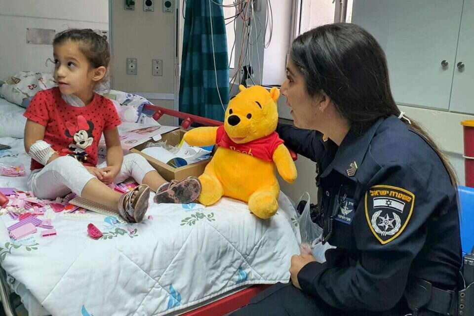 השוטרת רס"ל לי דרעי במפגש עם אוריאן, הילדה שנפגעה מרקטה בחולון , דוברות המשטרה
