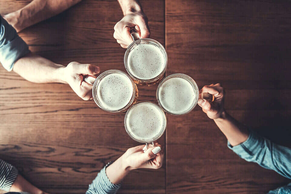 Cheers! Top view of people holding mugs with beer. *** Local Caption *** 06.08.19 , 