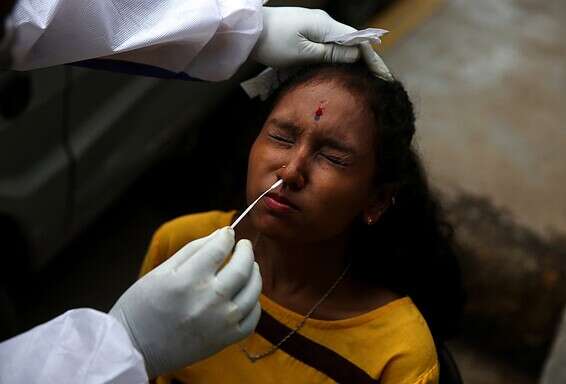 אישה עוברת בדיקת קורונה בהודו // צילום: רויטרס