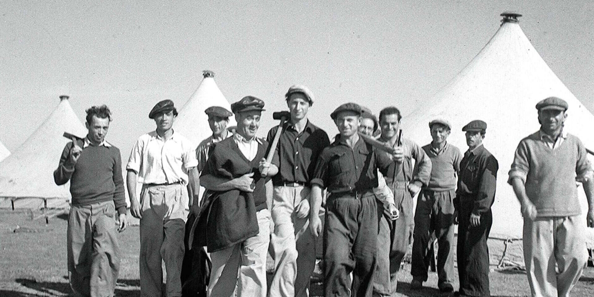 קבוצת פועלים מתנדבים מסייעת בהקמת אוהלים חדשים במעברת חירייה, דצמבר 1951 , הנס פין, לע"מ