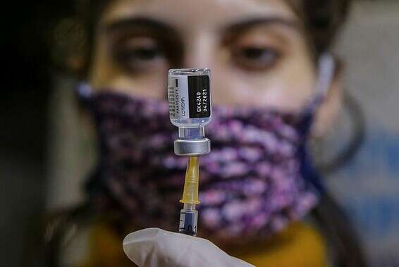 אישה מחזיקה בחיסון לקורונה, בירושלים, ביום שני // צילום: אורן בן חקון