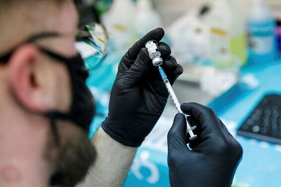 איש צוות רפואי מחזיק בחיסון נגד הקורונה, באשדוד, בשני // צילום: לירון מולדובן