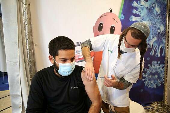 צעיר מקבל את החיסון לקורונה, בצפת, ביום שני // צילום: דוד כהן, ג'יני