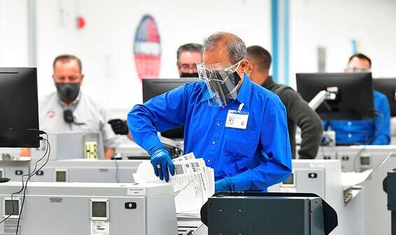 עובד בוועדת הבחירות בדאוני שבקליפורניה סופר קולות שהתקבלו, הלילה // צילום: איי.אף.פי.