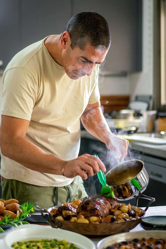 שישבנו לשולחן, הכל פתאום נרגע, ושלווה שרתה על כולם, אחרי החודש המטורף שעברנו. השף יוסי שטרית מכין את ארוחת הג // צילום: אסף קרלה