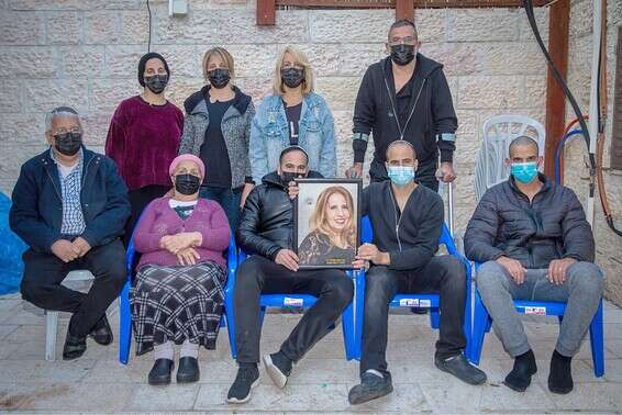 בני משפחתה של מרים כנפו (וקנין) עם תמונתה