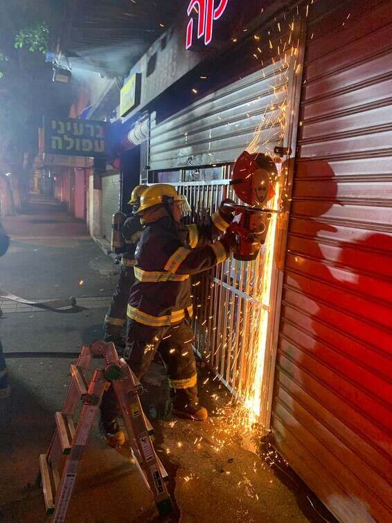 לוחמי האש פורצים לחנות באמצעות דיסק חיתוך // צילום: דוברות כבאות והצלה