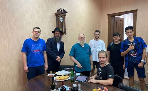 הרב חיים דנציגר, משמאל, מציג את ד"ר ישעיה שפיט, שני משמאל, ליהודים הממתינים למילה בבית הכנסת של רוסטוב על נהר הדון ברוסיה // צילום: באדיבות הקהילה היהודית של רוסטוב ,