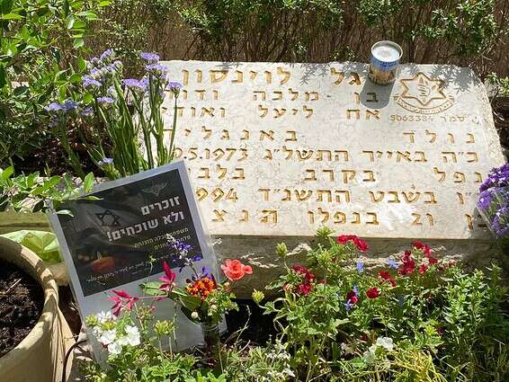 פרחים ונרות זיכרון על קברו של גל לוינסון