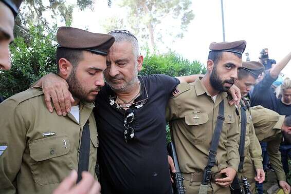 אביו של עמית ליד קברו עם החברים מסיירת גולני // צילום: גדעון מרקוביץ