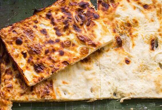 שתי יריעות בצק דקיק שביניהן מיני גבינות שנאפות בתנור. פלאצ'ינטה // צילום: איתיאל ציון