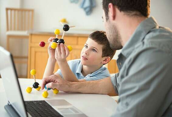 אב מעביר לבנו שיעור פיזיקה ביתי. "ילדים יודעים להוביל את הלמידה שלהם בעצמם, מתוך סקרנותם" // צילום: גטי אימג'ס