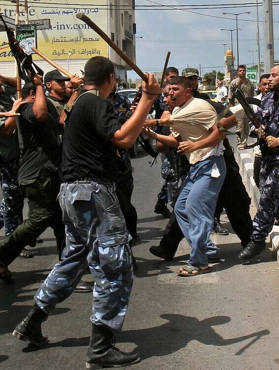 נמלט בעור שיניו מעזה. חיילי חמאס מכים תומכי פת"ח בעזה // צילום: AP
