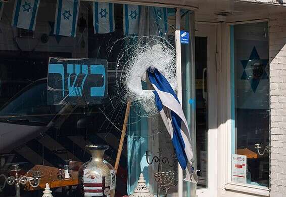 התוקף ניסה למשוך את דגל ישראל מהמסעדה ולהציתו // צילום: AP