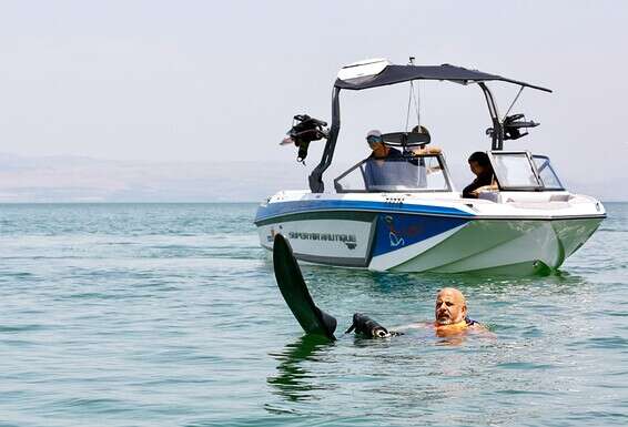 מאורי על רקע הסירה "NETTA" שהשיק לזכרה של רוטמן בכנרת. "חבל שהיא לא כאן לראות את האושר שמתפשט על פני הגולשים הנכים" // צילום: אורן כהן