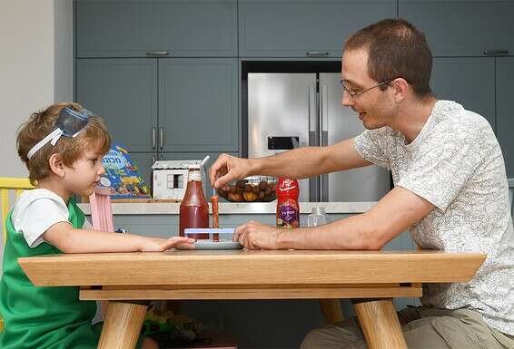 ארתור קלניצקי מעביר לבנו, גבריאל, שיעור בכימיה. כבר שנה שנייה שהם לומדים בבית  // צילום: אפרת אשל