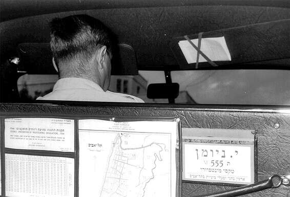 נהג מונית ופרטיו בגב המושב // צילום: פריץ לאנג, לע"מmhkuo: 