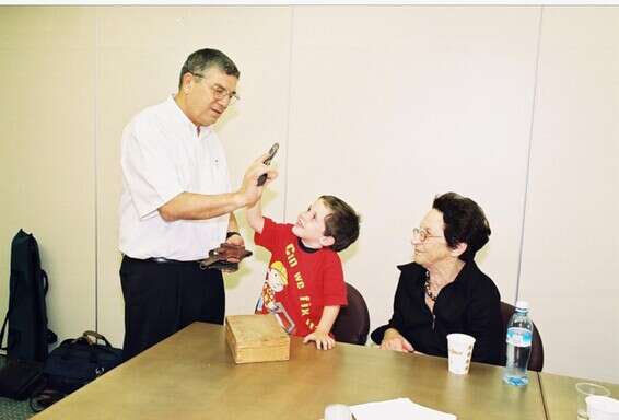 נעם בן ה-4 מפקיד את אקדחו של סבו // צילום: יד ושם