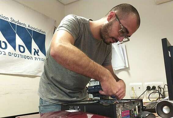 תומר רובינוב משפץ מחשב לתרומה. "טוב לראות את ההורים והילדים שמחים כל כך"