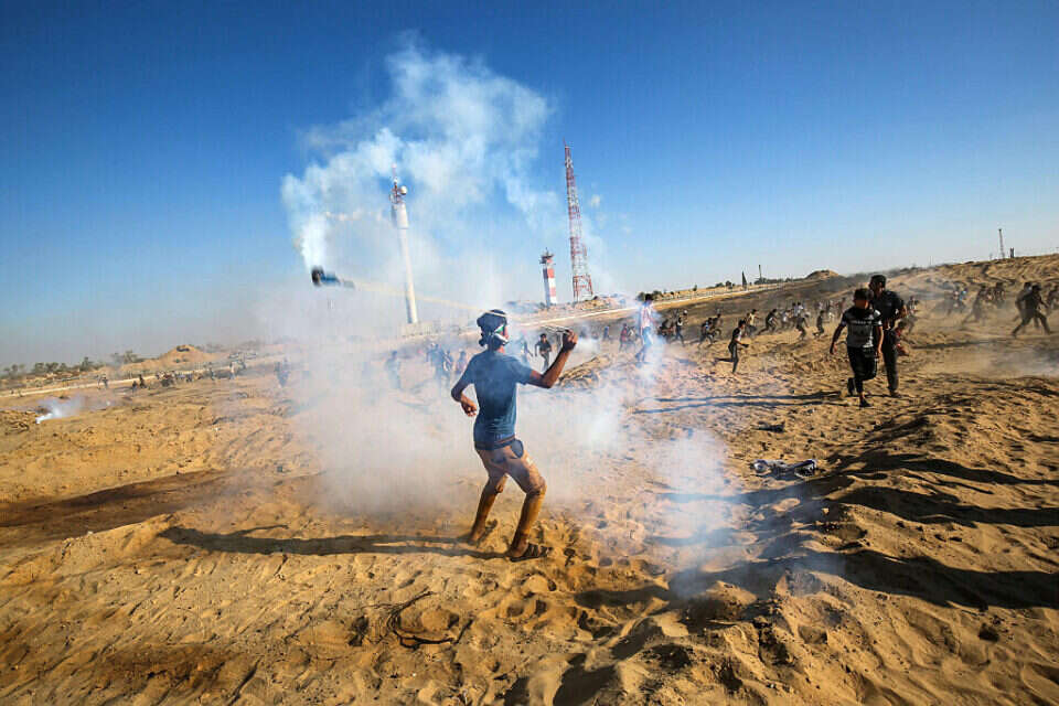 צילום: איי.אפ.פי // פלשתינים מתפרעים בגבול הרצועה ,