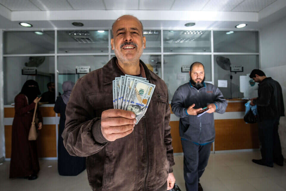הפלשתינים מקבלים את הכסף הקטארי בפעימות הקודמות // צילום: אי.אף.פי // הפלשתינים מקבלים את הכסף הקטארי בפעימות הקודמות // צילום: אי.אף.פי ,