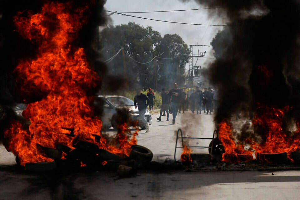 פלשתינים מבעירים צמיגים בג'נין במהלך עימותים עם כוחות צה"ל, השבוע , רויטרס