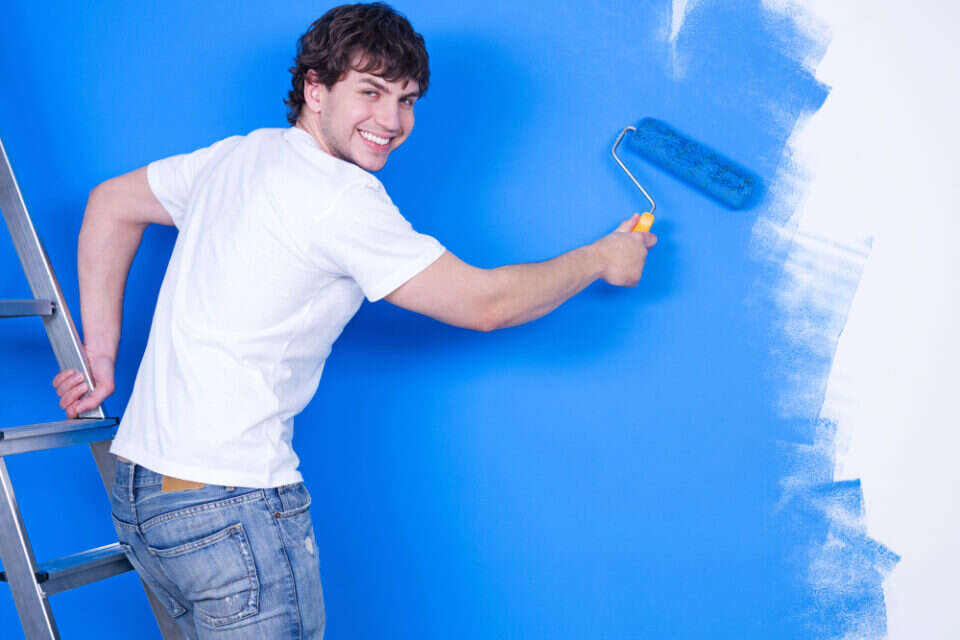 handsome-young-man-with-happy-smile-painting-wall-960x640.jpg