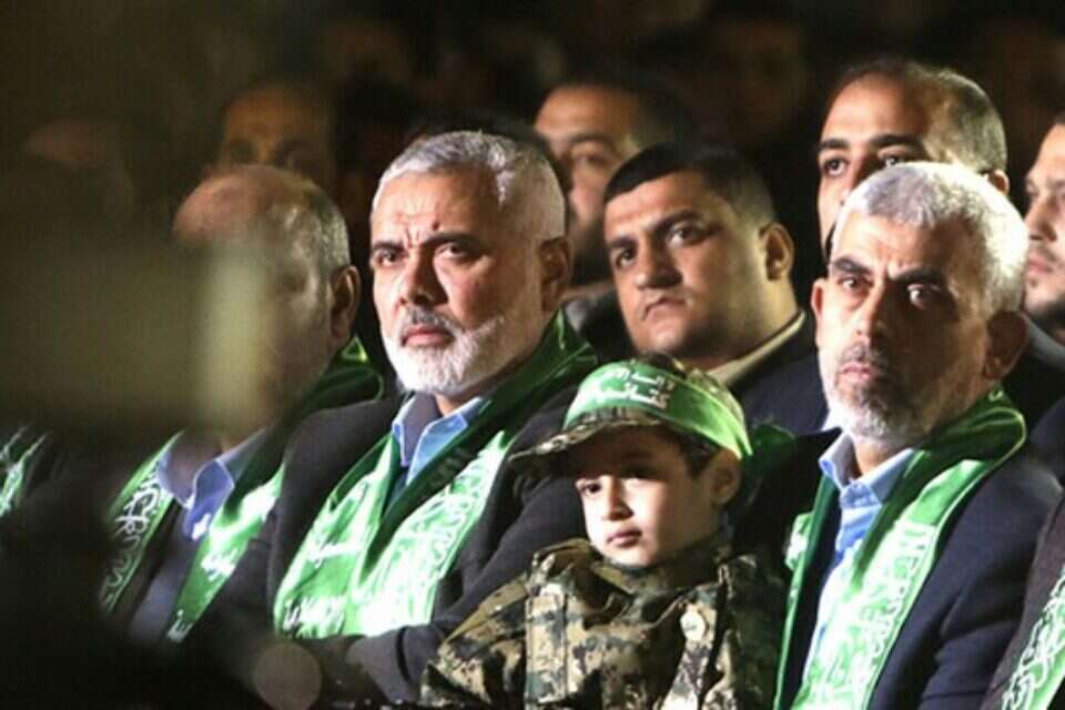 יחיא סינוואר (במרכז) ובנו של פוקהא על ברכיו. משמאל: הנייה // צילום: אי.אף.פי // יחיא סינוואר (במרכז) ובנו של פוקהא על ברכיו. משמאל: הנייה // צילום: אי.אף.פי ,