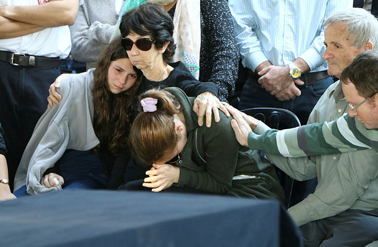 משפחת ניר בבית העלמין לצד ארונותיהם של עמרי ובנו עילי // צילום: אמיר מאירי