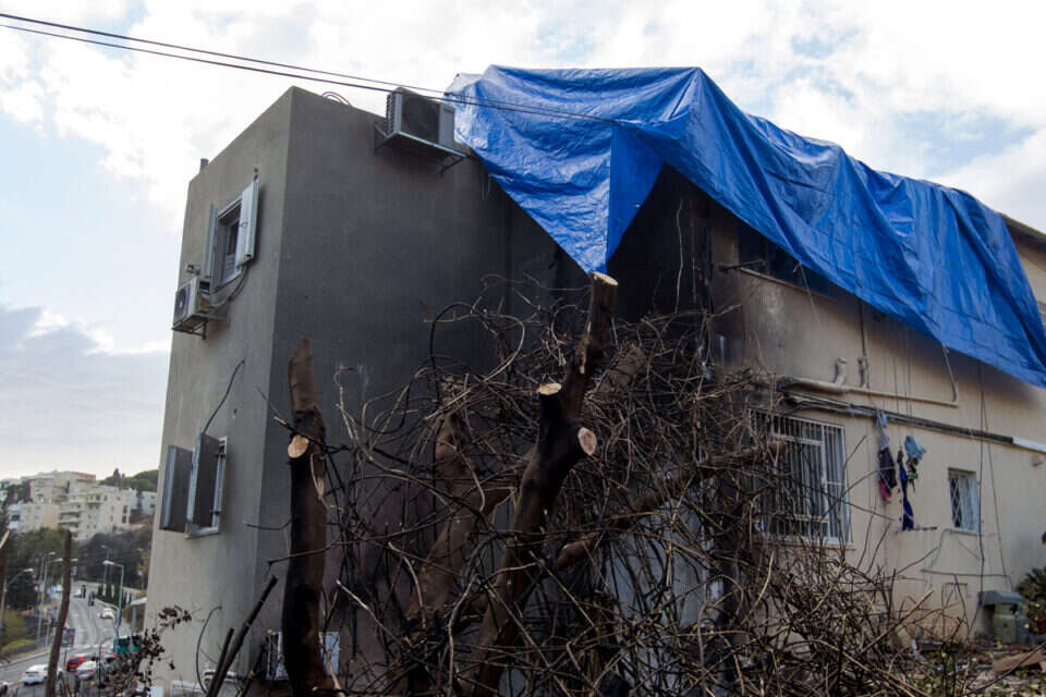 נערכים לסערה. מכסים בתים שנפגעו בשריפה בחיפה, לקראת הגשם // צילום: מישל דוט קום ,