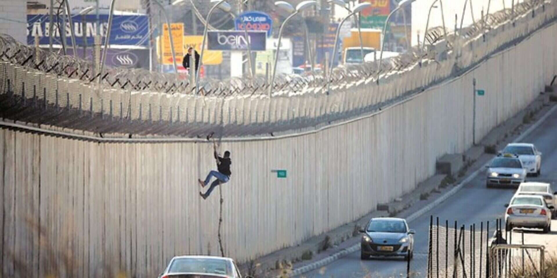 פלשתיני נעזר בחבל כדי לחצות את גדר ההפרדה במזרח ירושלים (ארכיון) , איי.אף.פי