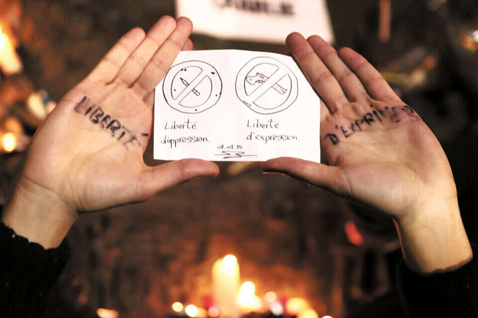 צילום: אי.אף.פי // היכן ערכי המהפכה? אישה שעל ידיה הכיתוב "חופש הביטוי" בעצרת בכיכר הרפובליקה, לאחר הטבח ,