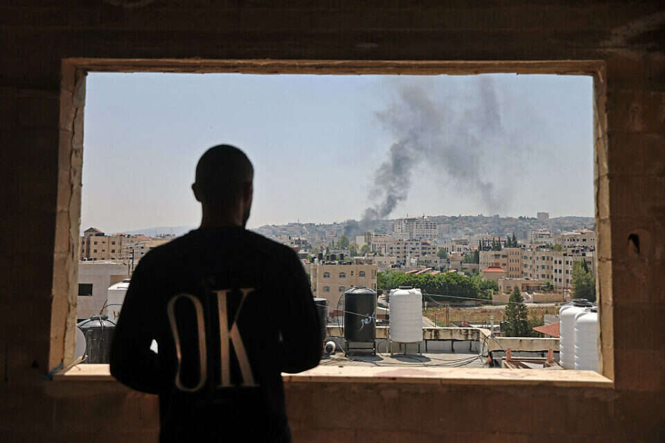 פלשתיני מביט על העשן מיתמר מעל ג'נין , איי.אף.פי