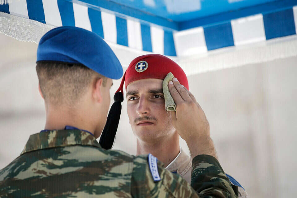 קצין מנגב את הזיעה מפניו של חייל במשמר ארמון הנשיאות, אתונה , אי.פי.אי