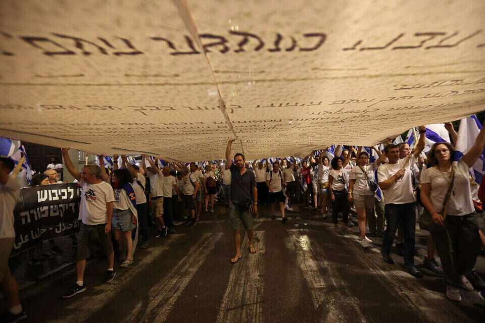 המונים צועדים בת"א עם עותק ענק של מגילת העצמאות