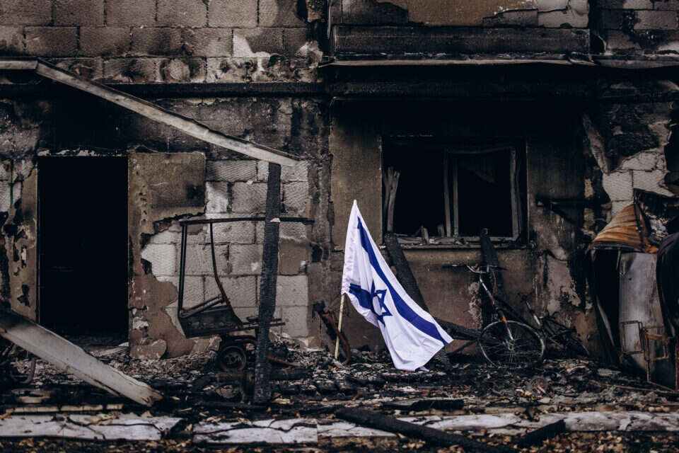 דגל ישראל מונף ליד בית שרוף בקיבוץ בארי (ארכיון) , מיכה בריקמן