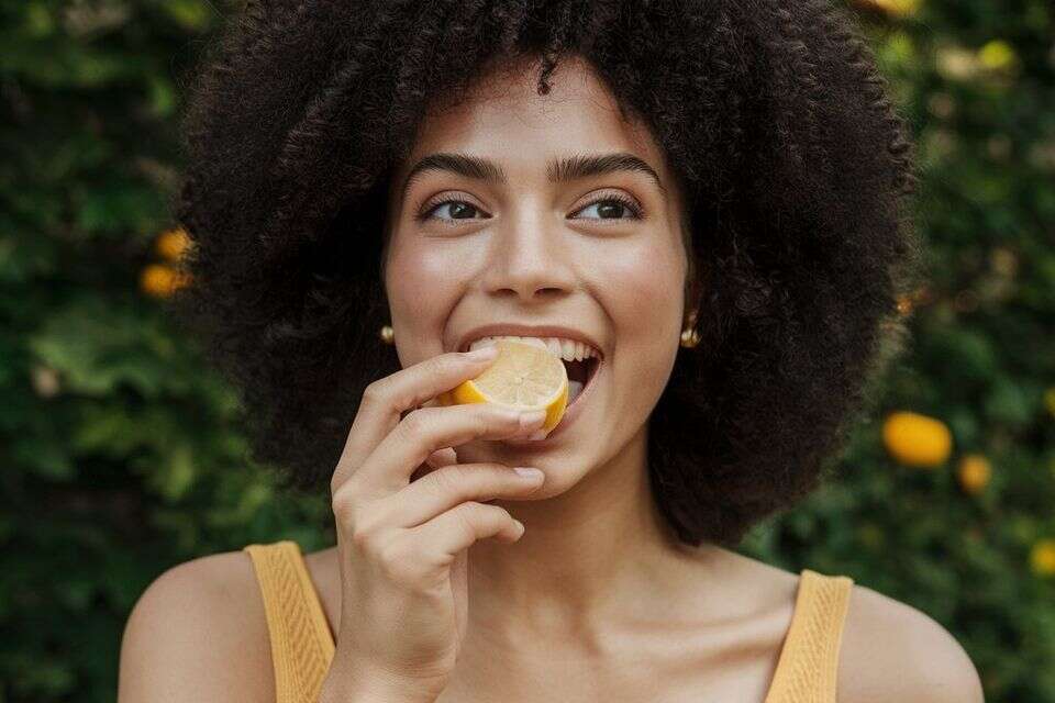 אישה אוכלת לימון עם חיוך על הפנים , מערכת feedy באמצעות הבינה המלאכותית ideogram
