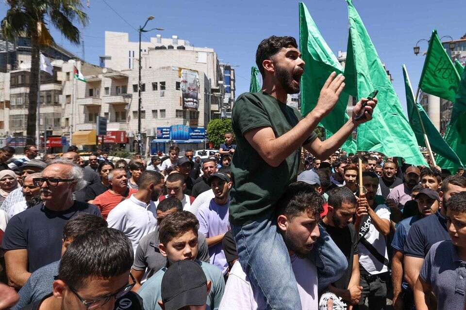 מפגינים נושאים את דגל חמאס ברמאללה לאחר חיסולו של איסמעיל הנייה, ביולי 2024 , איי.אף.פי.