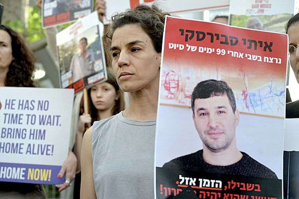 לא מאוחר לבחור בחיים. מרב מפגינה עם תמונת אחיה , בן כהן
