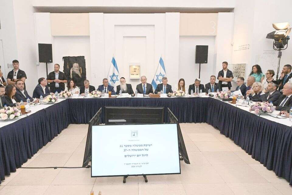 העצור (מטושטש משמאל) בישיבת ממשלה , ללא קרדיט