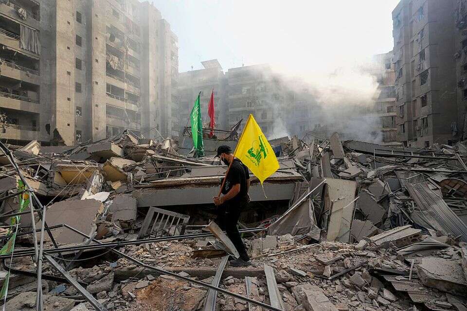 תומך חיזבאללה לצד הריסות ברובע הדאחייה , אי.פי