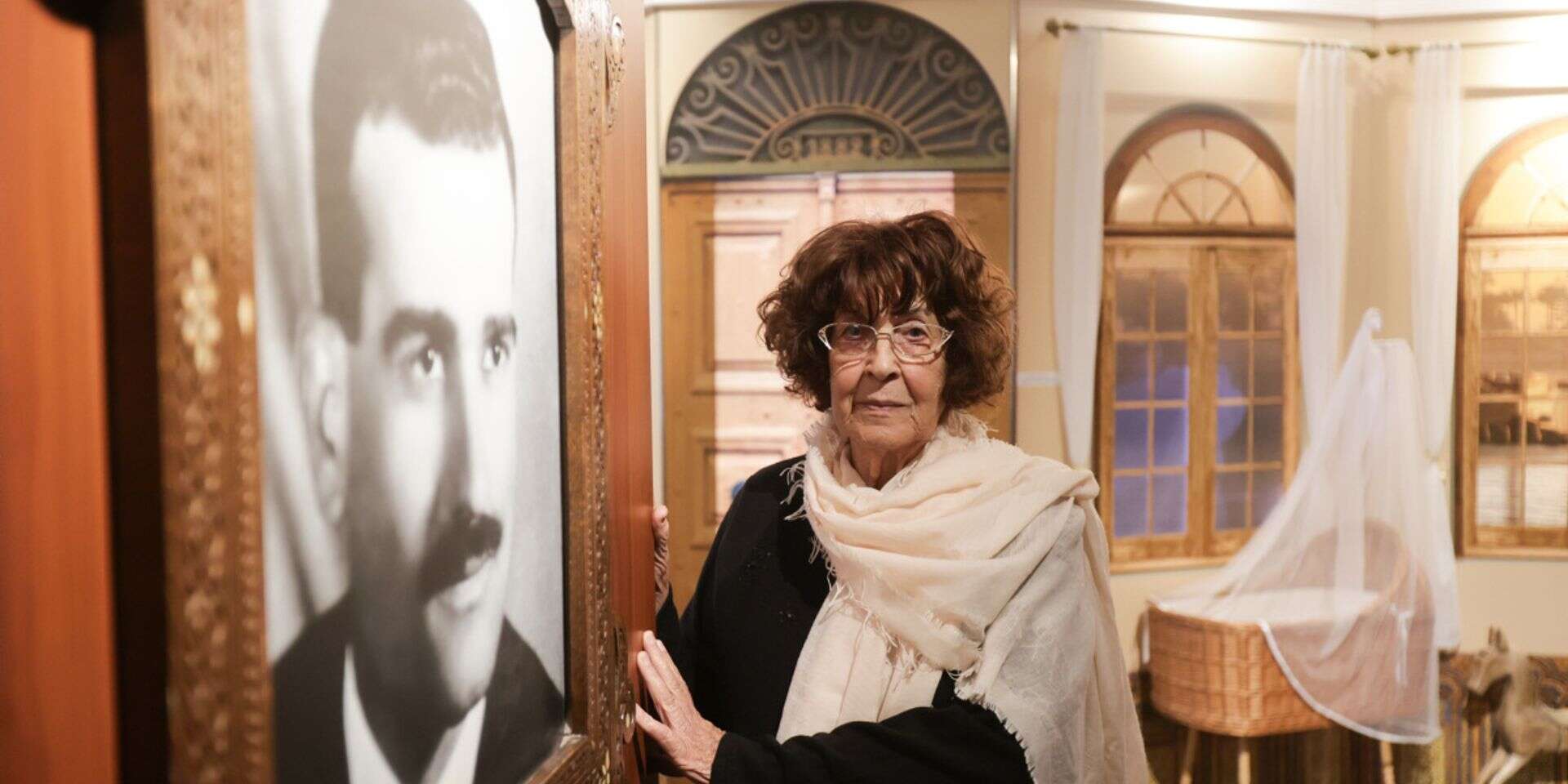 נדיה כהן ליד תמונת בעלה אלי ז"ל במוזיאון לזכרו , ללא