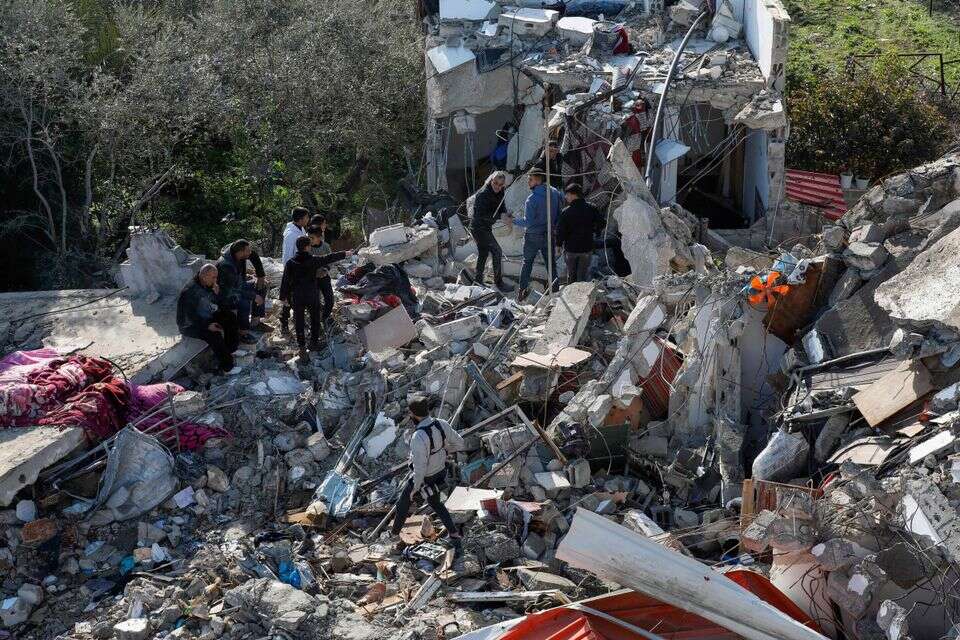 פלתשינים בודקים את הריסות הבית בו חוסלו שני המחבלים שביצעו את הפיגוע בפונדוק , אי.אף.פי