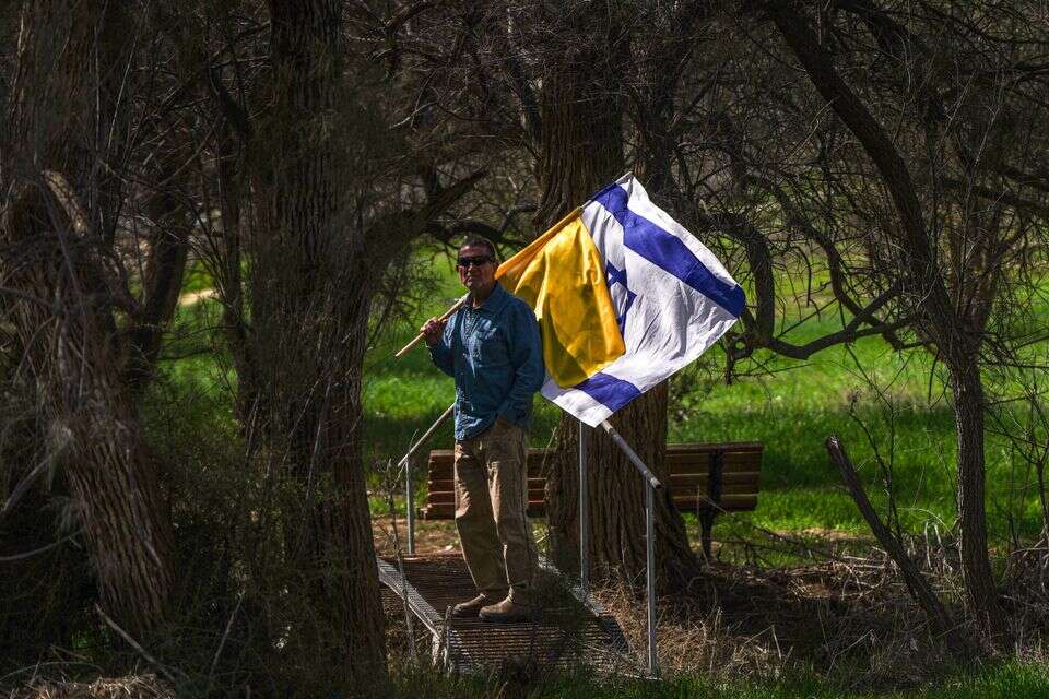 אזרח עם דגל ישראל בכניסה לקיבוץ ניר עוז, לקראת הלוויתו של אוהד יהלומי ז"ל , ללא