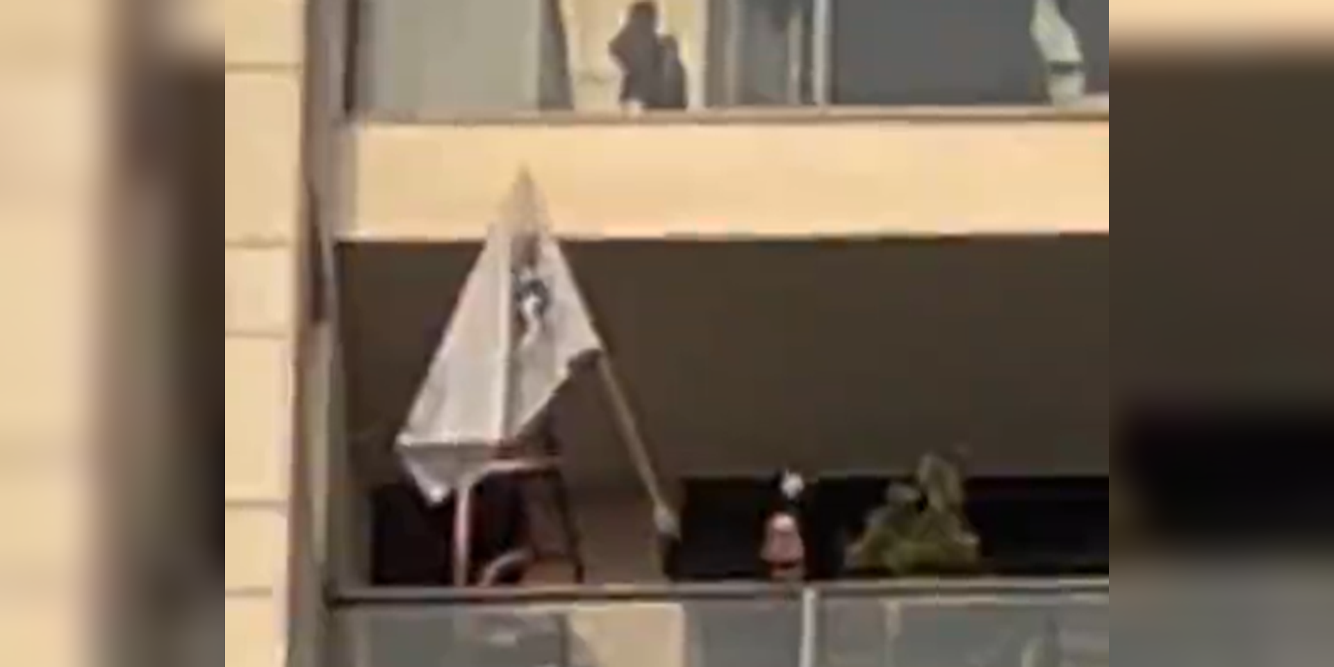 בן זוגו של אוחנה, אלון, מניף אצבע משולשת למפגינים מתחת לביתו , ללא