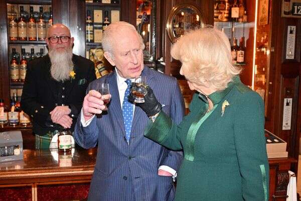 המלך צ'ארלס השלישי והמלכה קמילה טועמים וויסקי ב-The Friend at Hand במהלך ביקור ברובע המסחרי, בלפסט, ביום הראשון לביקורם בצפון אירלנד, יום רביעי, 19 במרץ 2025 , Samir Hussein/PA via AP