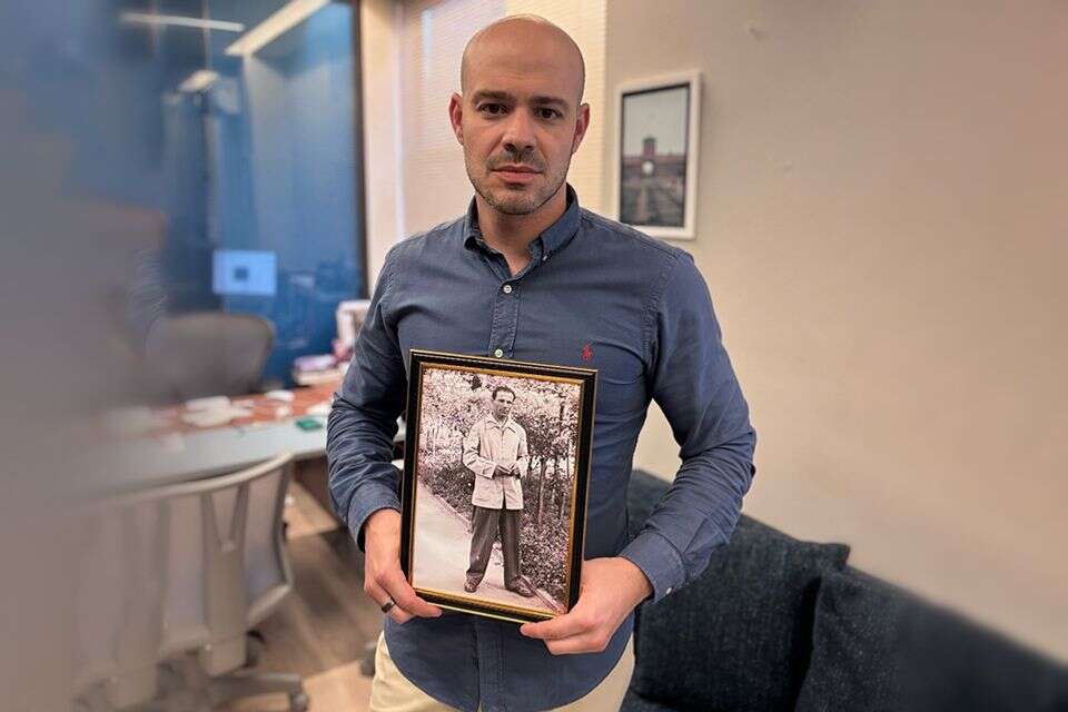 אנדרה לייסט, מנכ"ל "StandWithUs" ברזיל עם תמונה של סבא שלו, שורד השואה , באדיבות המצולם